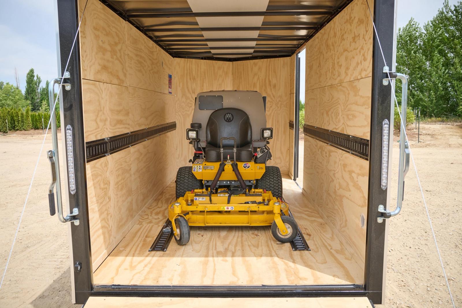 Enclosed trailer with a yellow riding lawnmower inside