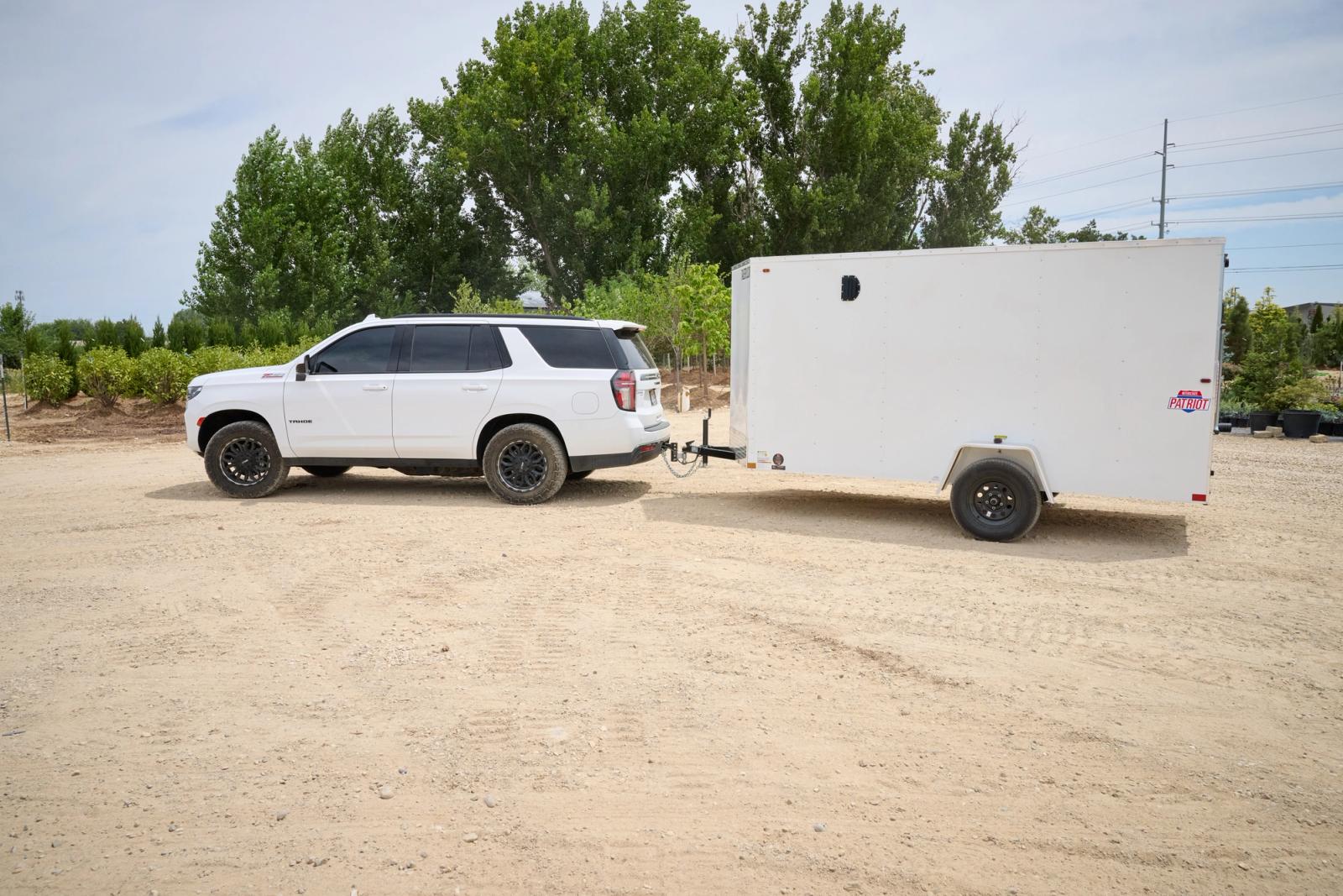 White Tahoe SUV towing a white 6x12 patriot cargo trailer