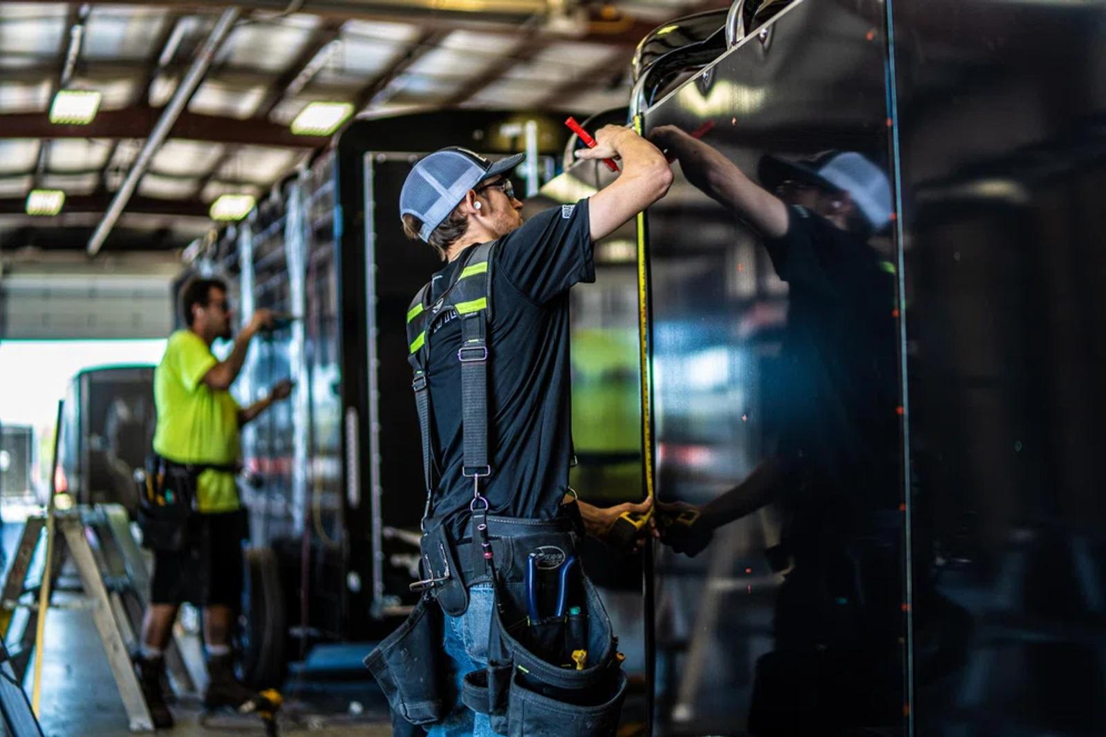 TrailersPlus employee servicing a cargo trailer