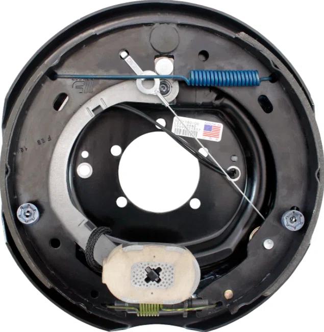 Close-up of an exploded trailer drum-brake assembly showing the backing plate, springs, and brake lines