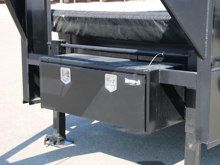 Close-up of a black Buyers Products gooseneck tongue toolbox mounted beneath the neck of a black gooseneck trailer
