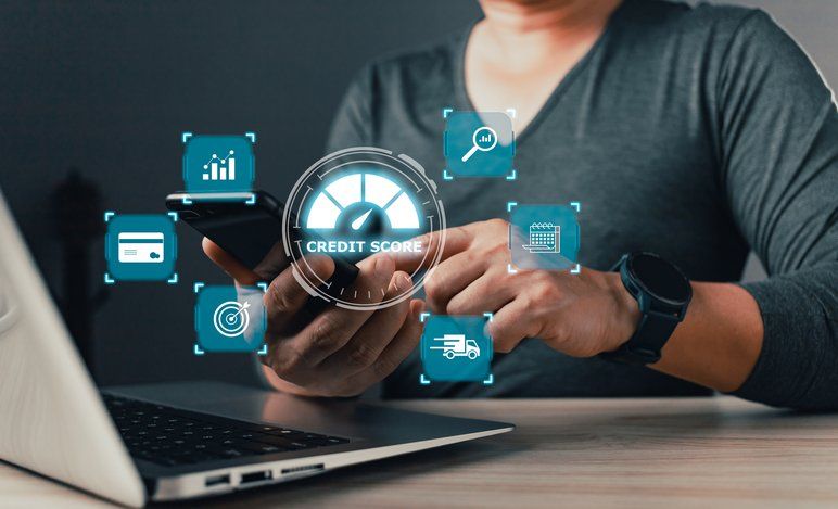 Stock photo of a person holding a smartphone with a glowing 'Credit Score' meter graphic and finance icons floating around it
