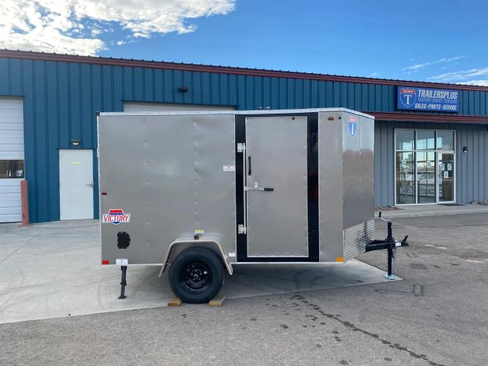 Silver Interstate Victory enclosed cargo trailer parked in front of a TrailersPlus Sales, Parts and Service dealership building