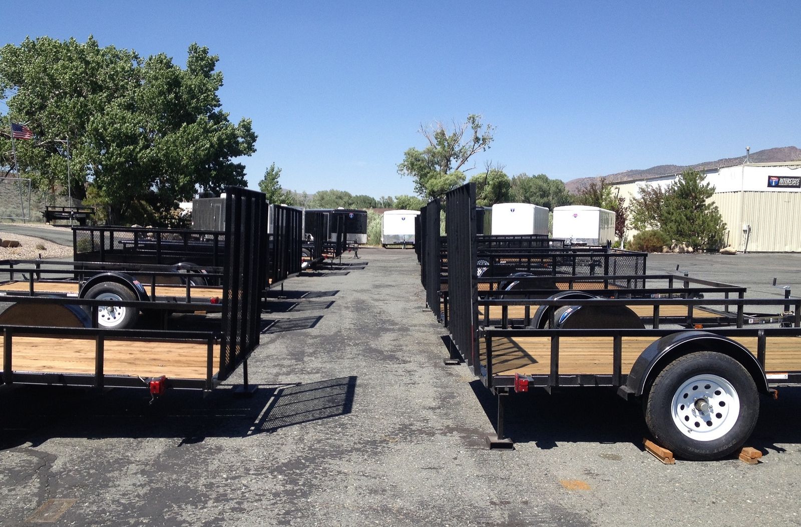 Multiple utility trailers in a row with blue skies