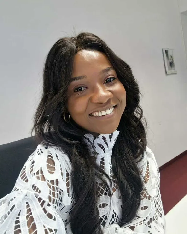 Ngenyi Stella Menjua, founder of Roots and Reach e.V., smiling at her desk