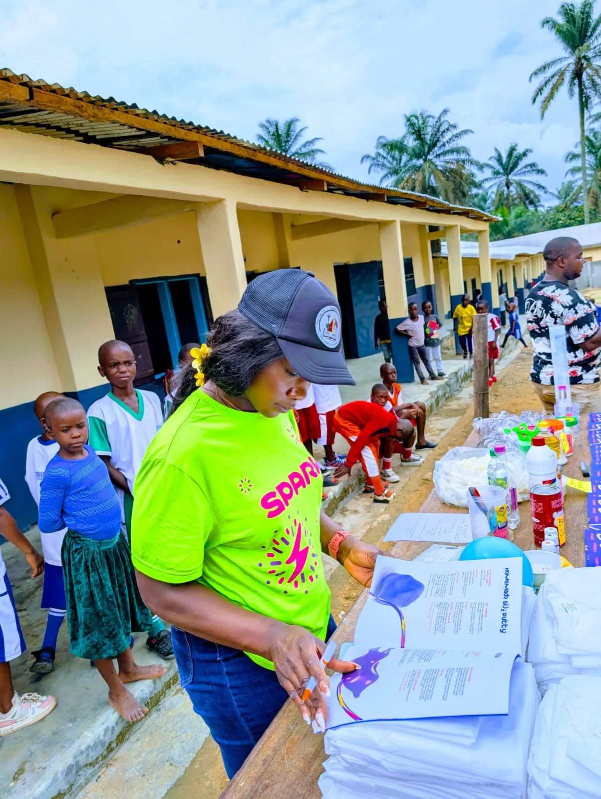 A volunteer reading through an experiment booklet while pupils look on