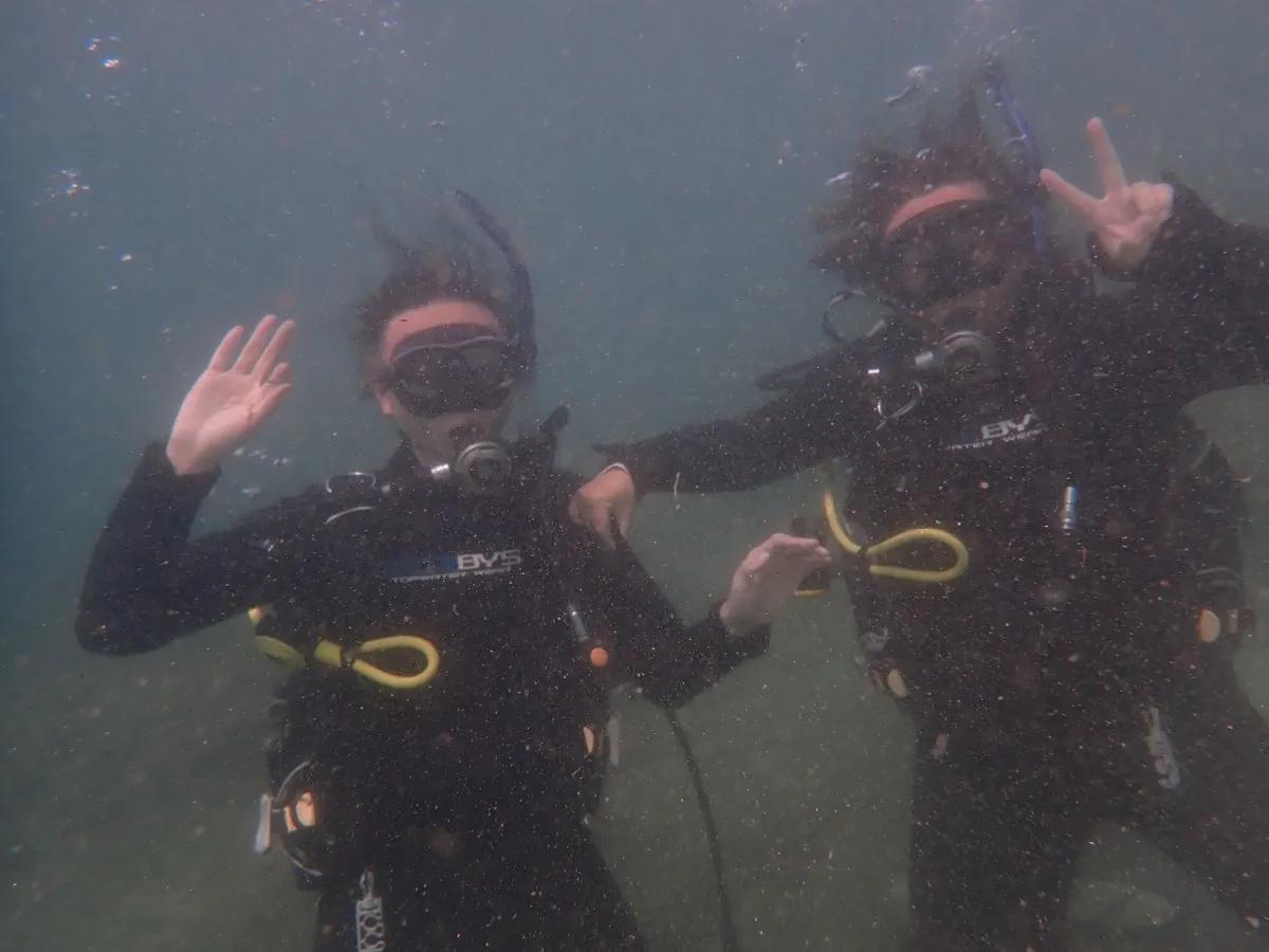 三浦の海で体験ダイビング中、水中でカメラに手を振るお二人
