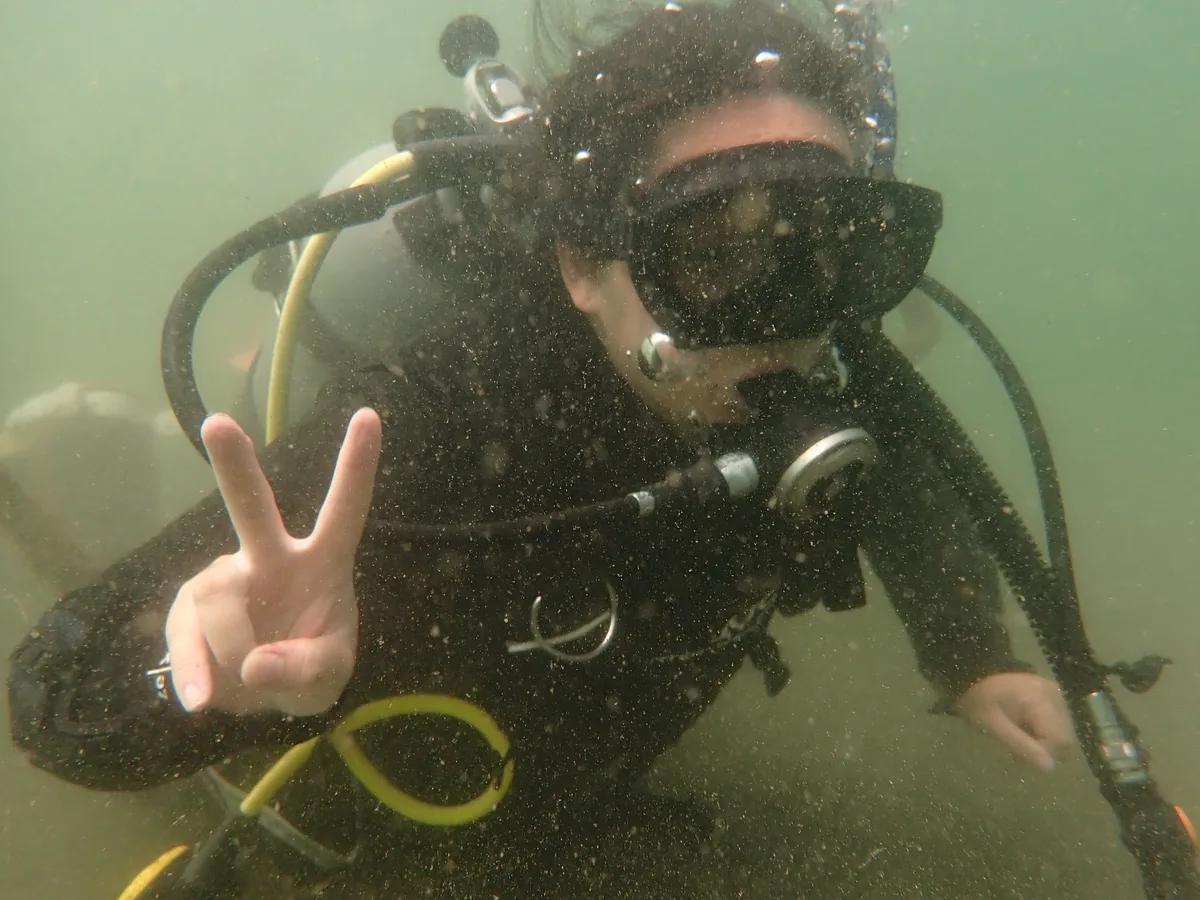 三浦・城ヶ島でのダイビング講習中、水中でピースサインを出すダイバー