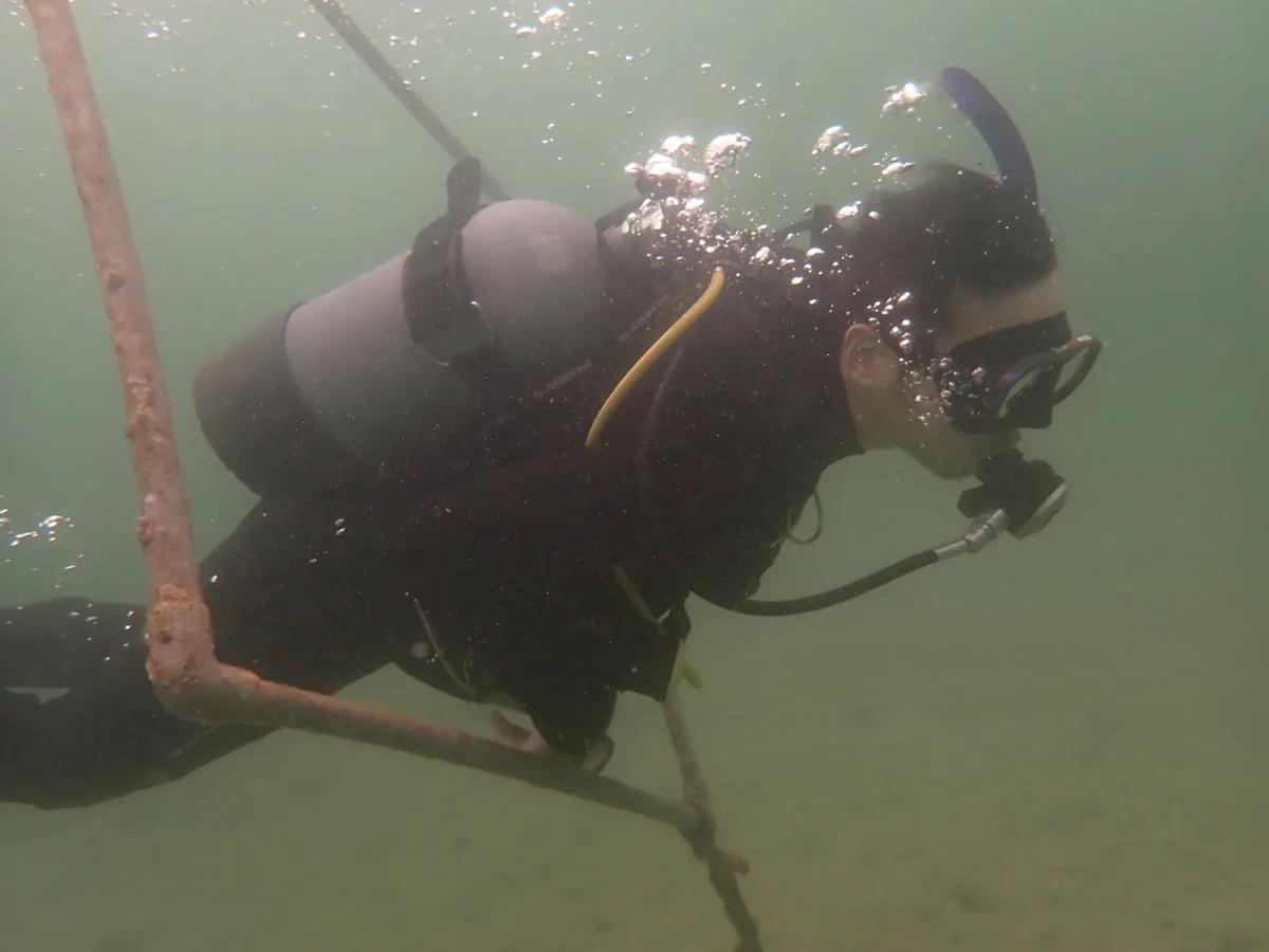 三浦の海で海洋実習中のダイバー。エントリー口の手すりのそばで中性浮力を確認する