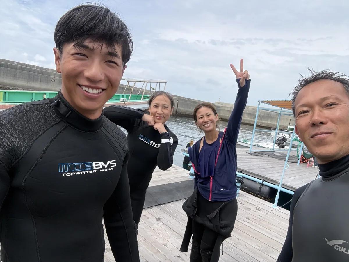 ダイビングを終えて筏の上で笑顔のゲストとスタッフ