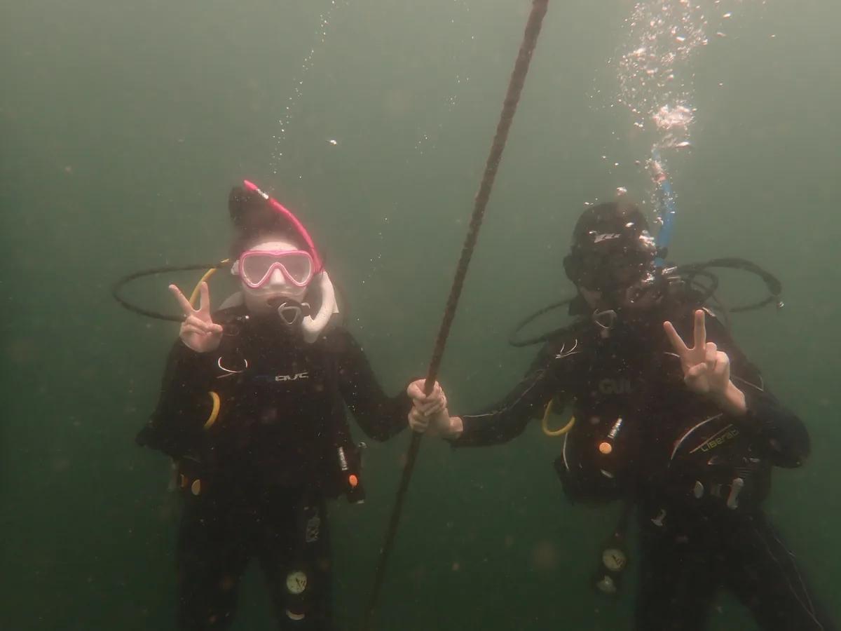 水中でロープにつかまり安全停止をするダイバー2人。三浦でのアドバンス講習