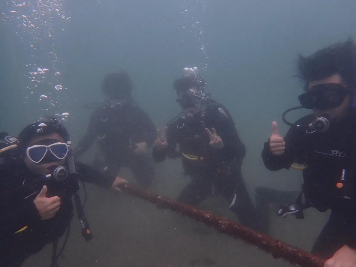 三浦の海で講習中、水中でロープにつかまるOWD講習生4名