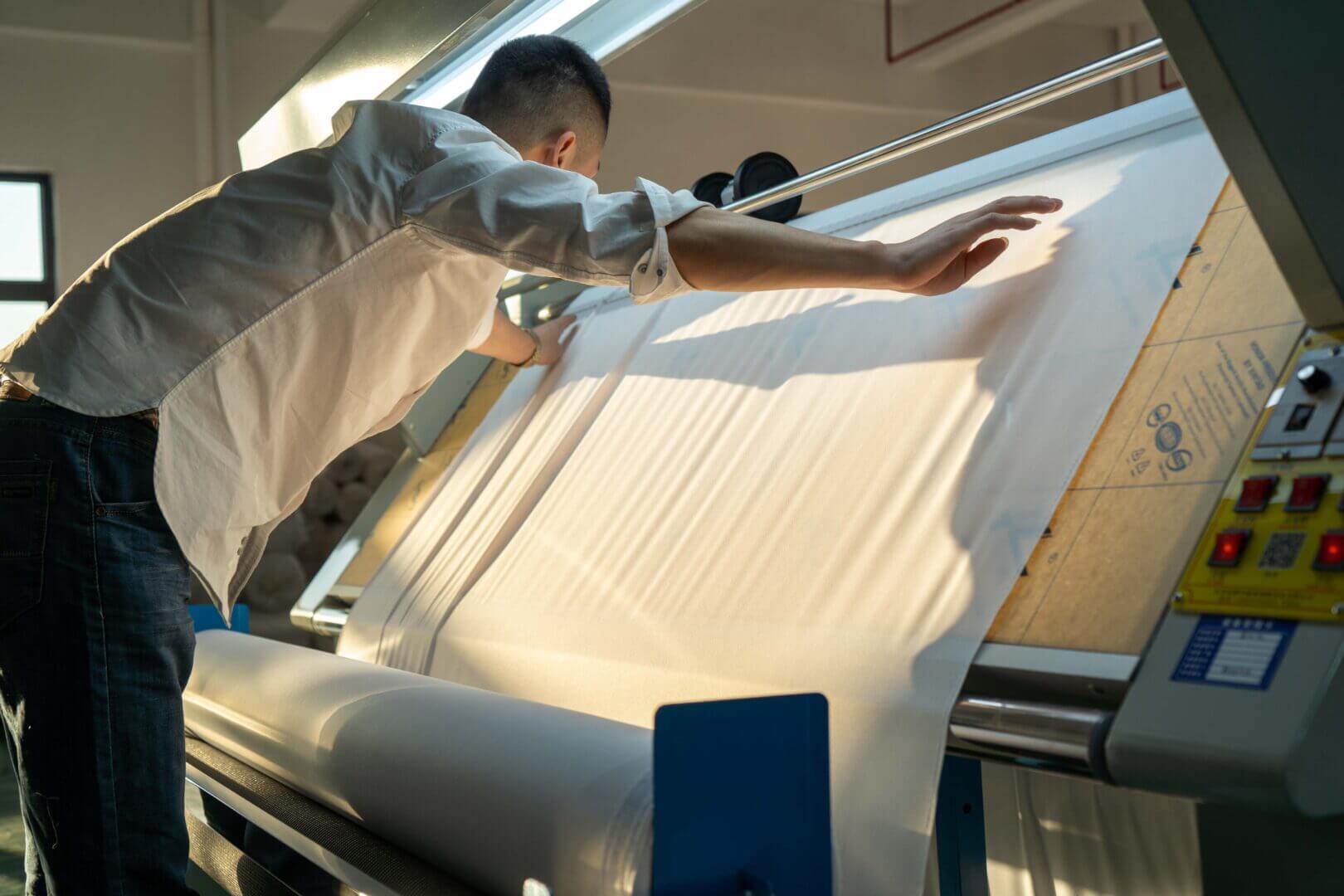 A man placing fabric on printer