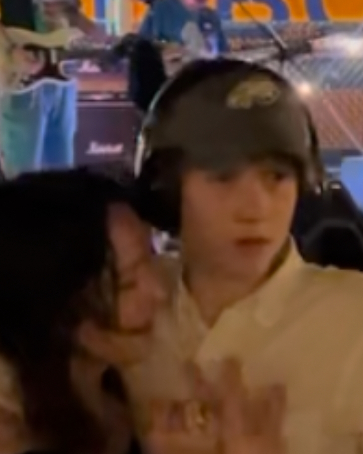 A Heartwarming Moment Dancing Together A blurry image of a mom and her son sharing a close moment while dancing at a live band performance. The boy, wearing headphones, looks engaged and happy, highlighting the joy of being together in a festive atmosphere.