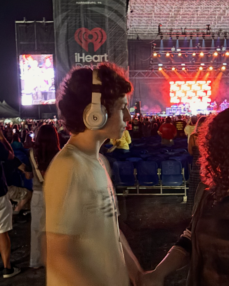 Halen wearing headphones and enjoying the Rick Springfield concert at an outdoor venue