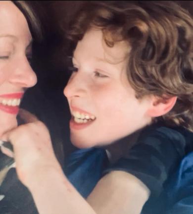 racie Smith and her son Halen smiling warmly at each other in a candid and joyful moment, showcasing their close bond.