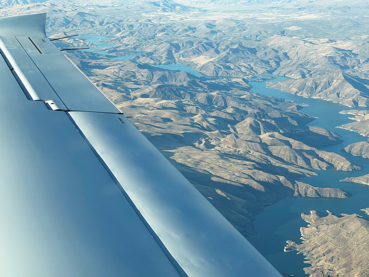 Aerial view of Idaho canyon country and a reservoir from the aircraft wing