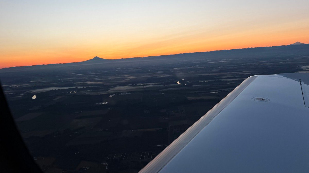 Sunrise over the Cascades with Mount Hood on the horizon, seen from the aircraft