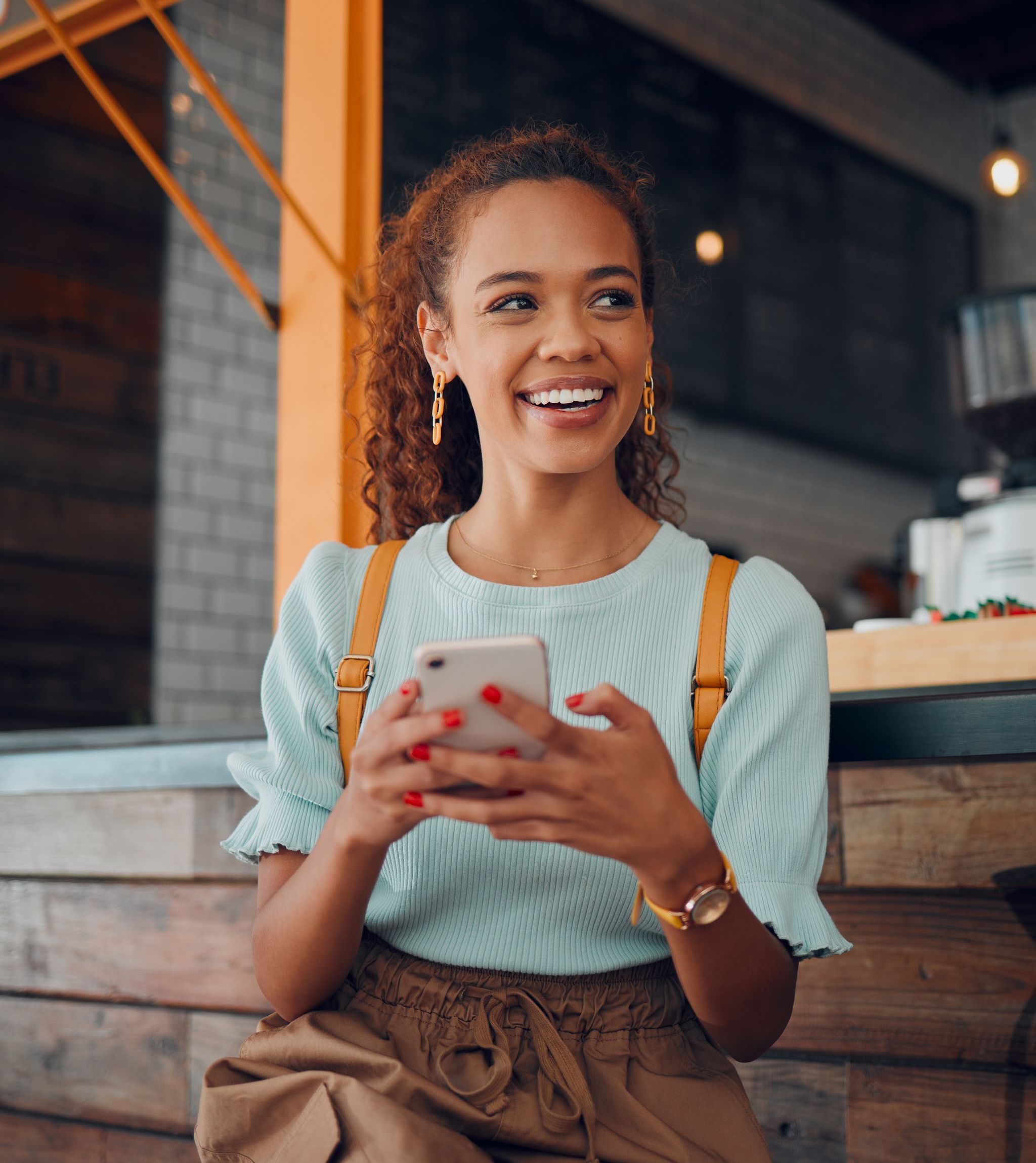 Young lady smiling while holding her mobile phone