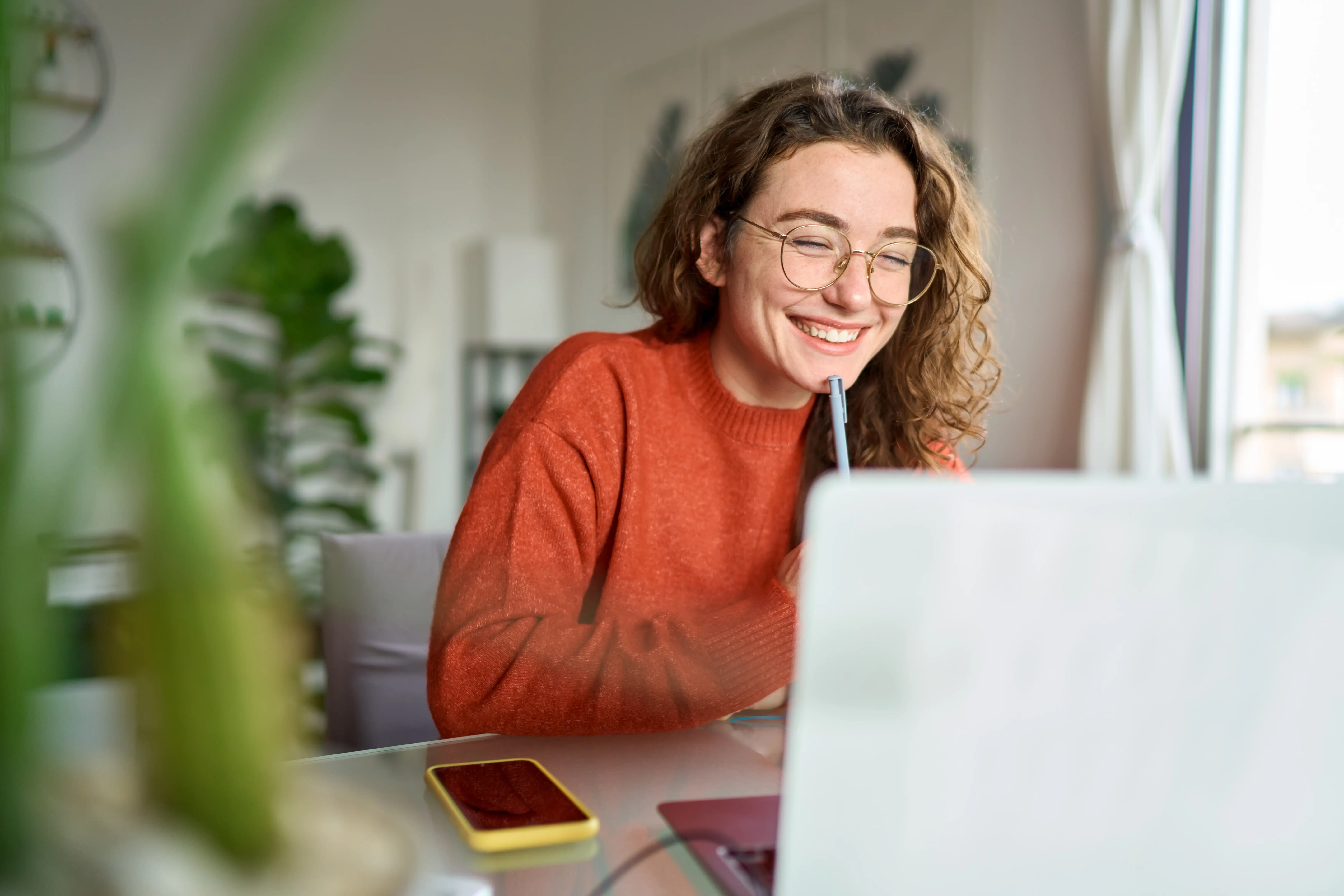 Young woman smiling as she checks her laptop