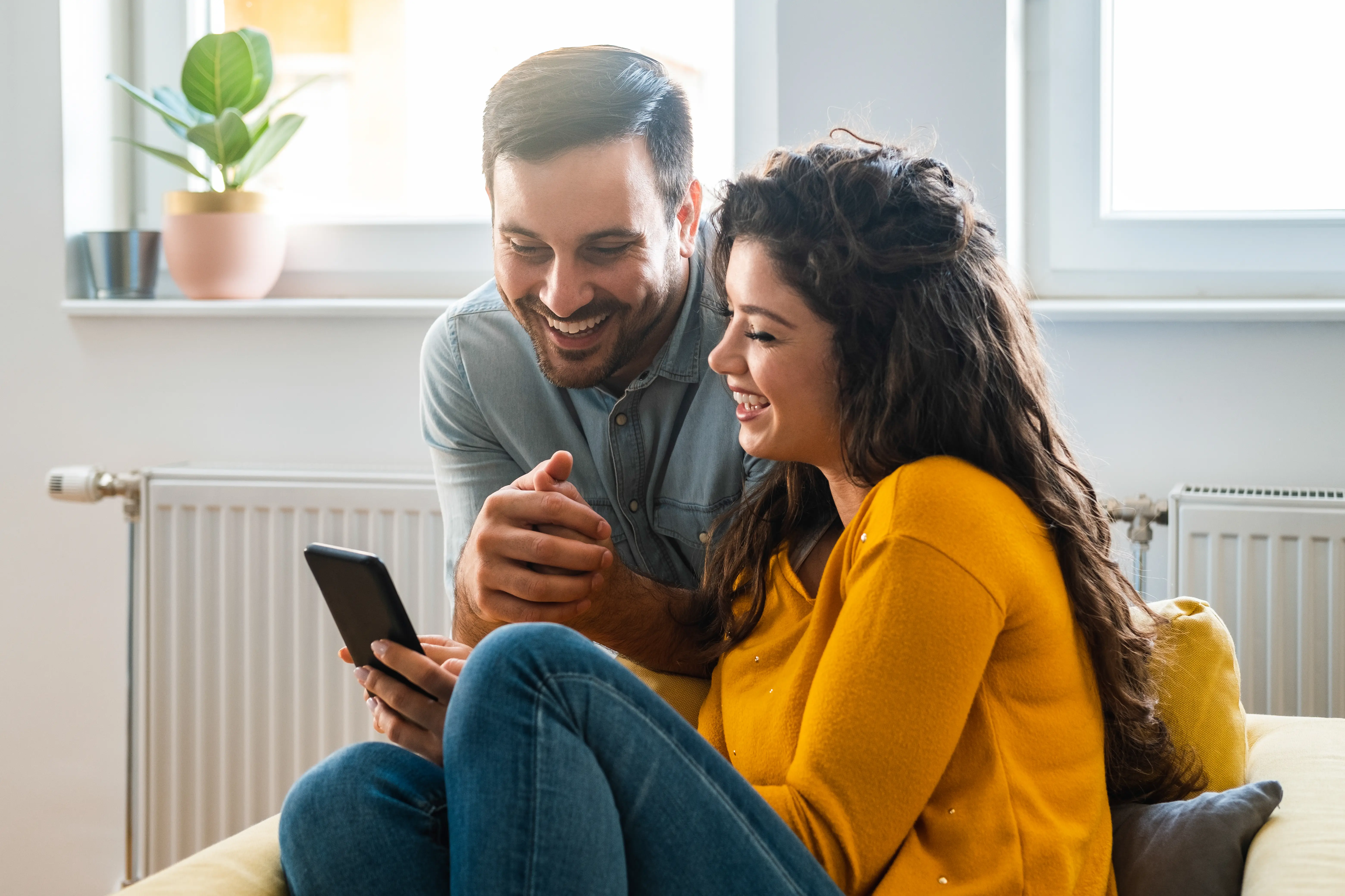 A couple checking loan results on their mobile at home