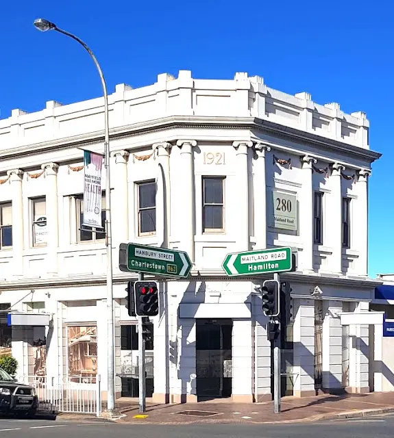Street in Mayfield with a white bricked corner building and traffic lights