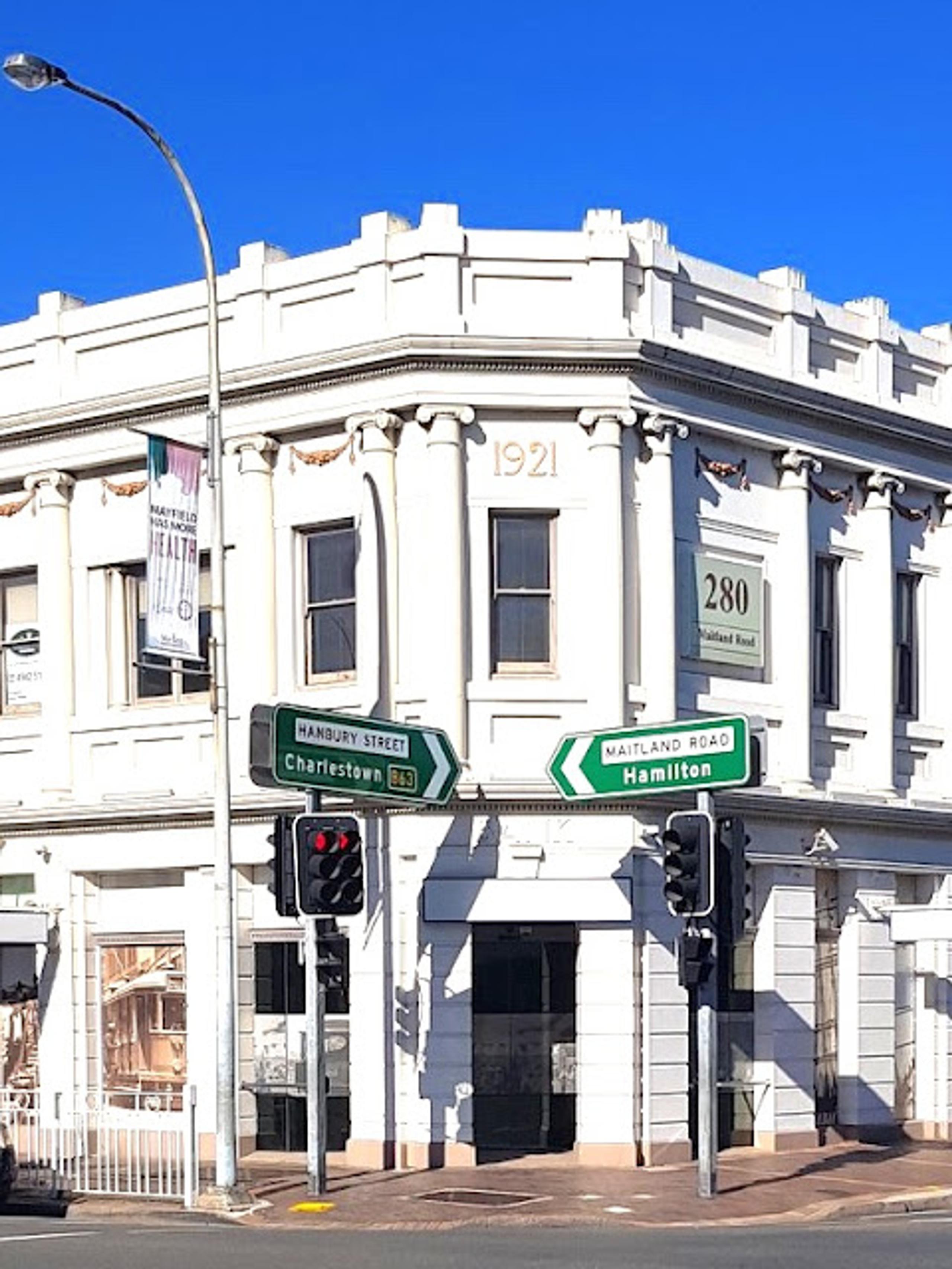 Street in Mayfield with a white bricked corner building and traffic lights