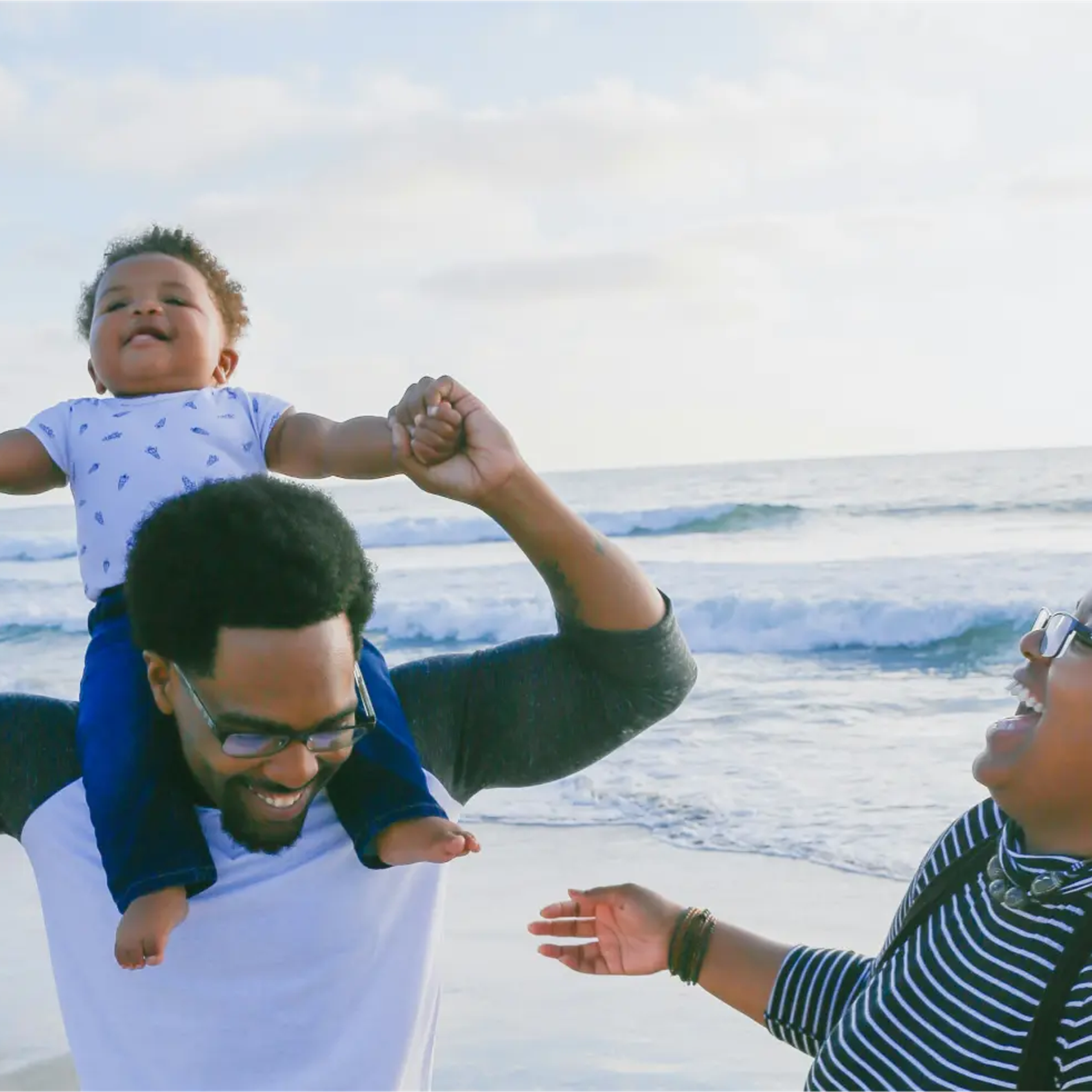 A couple with their young child at the ocean