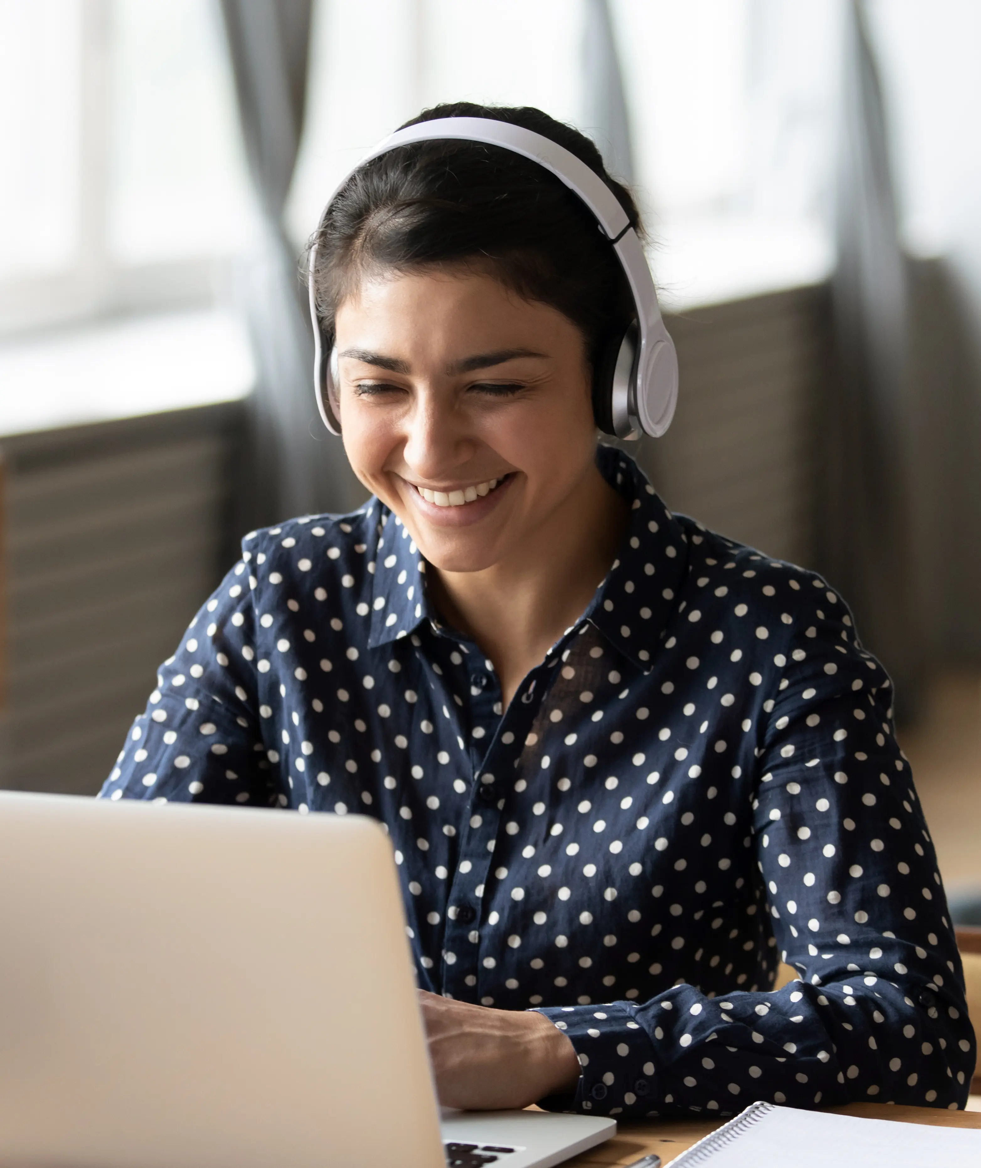 Woman on laptop with headphones