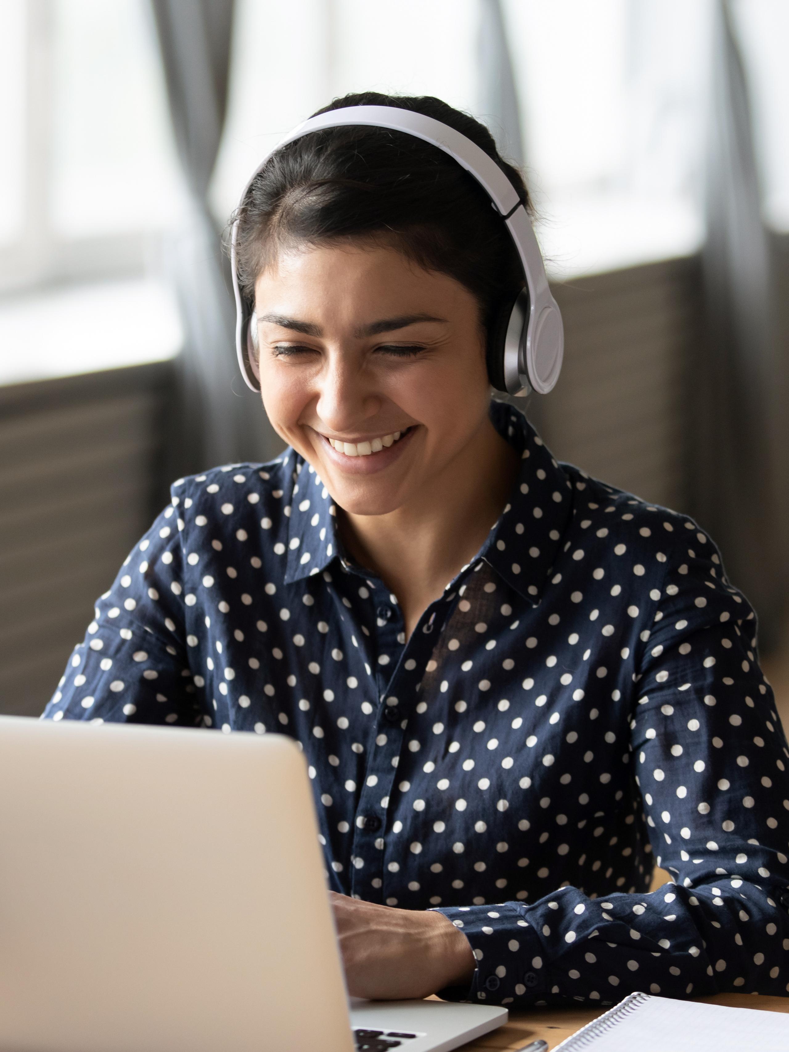 Woman on laptop with headphones