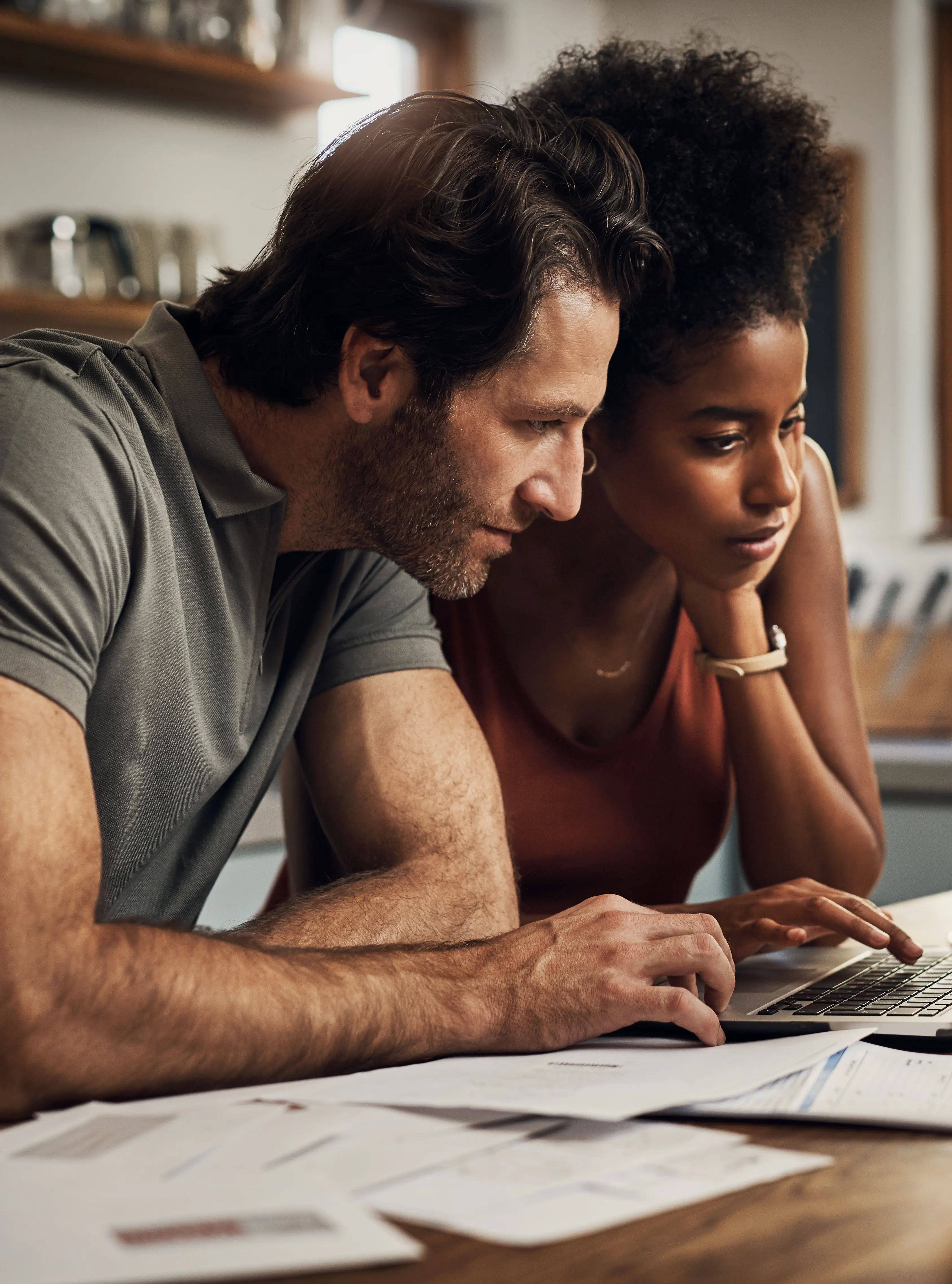 A couple at home checking their financial paperwork and checking on their laptop