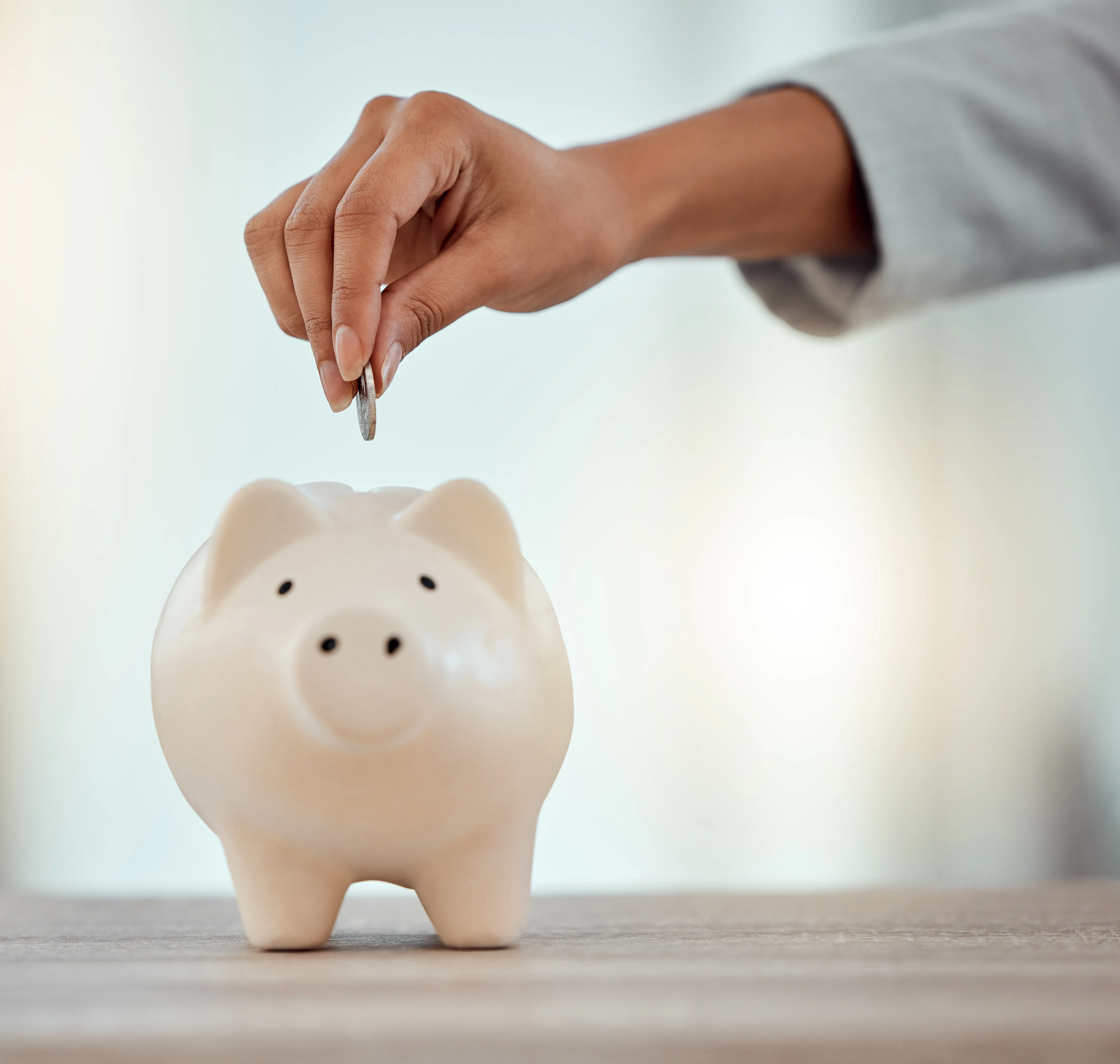 Putting coins into a piggy bank