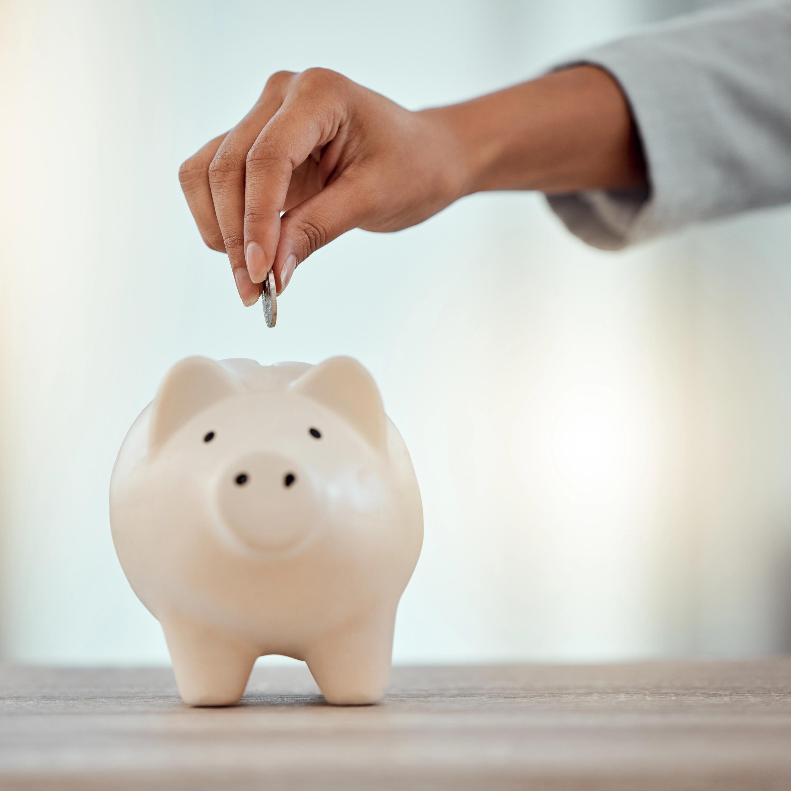 Putting coins into a piggy bank