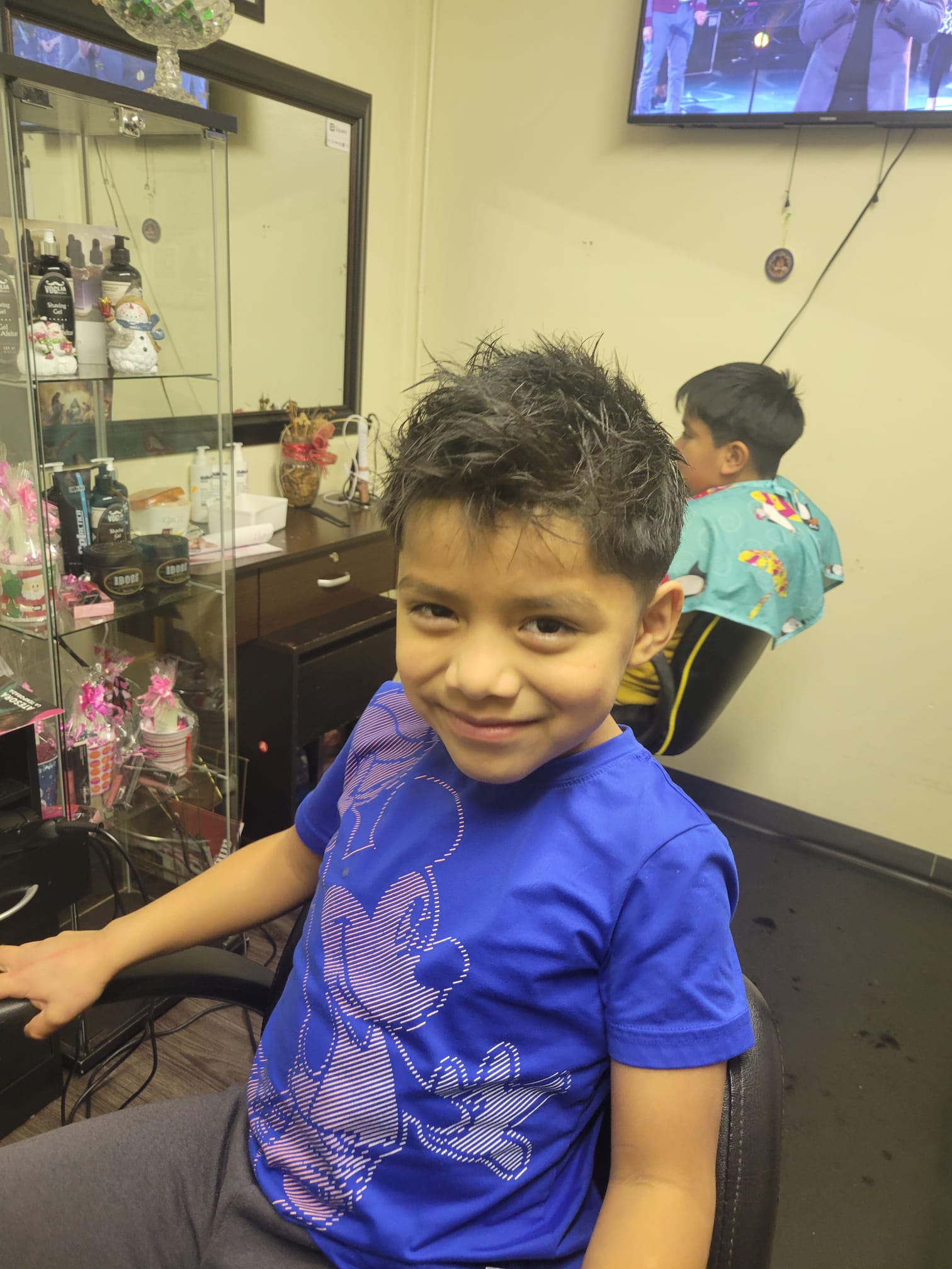 The top hair is left longer and styled in a spiky, tousled fashion for a textured look, while the sides and back feature a smooth, gradual fade that tapers down to the skin near the ears. It’s a modern and clean haircut that works well for younger individuals.