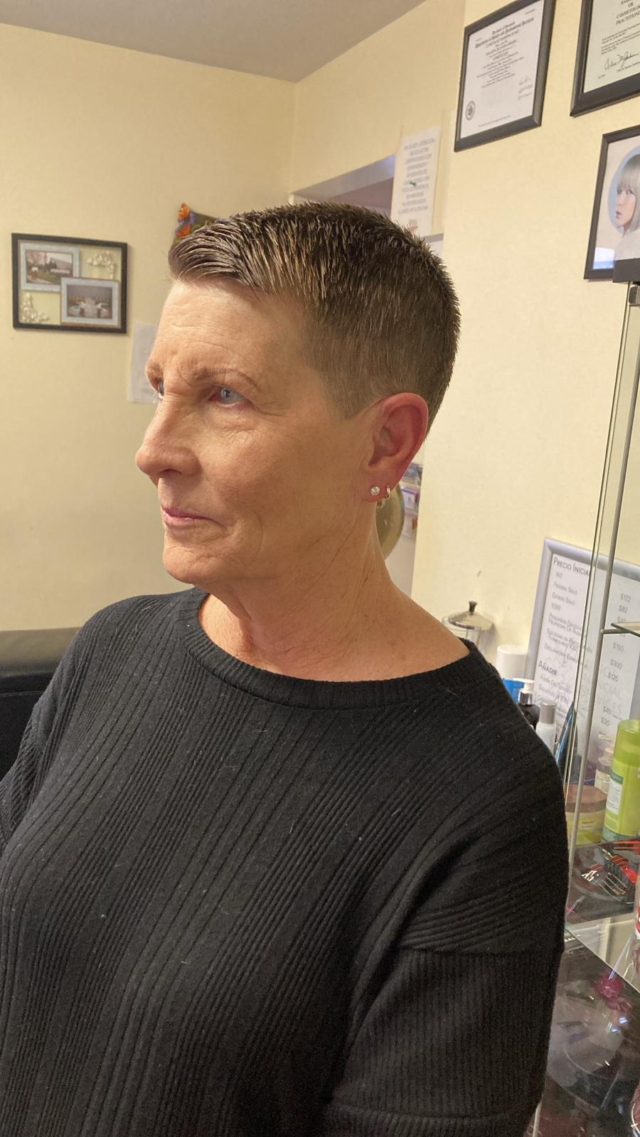 The hairstyle is a sleek, short cropped cut with neatly tapered sides and back, blending seamlessly into the slightly longer hair on top. The top is styled flat and combed back, giving a polished, clean, and low-maintenance look.