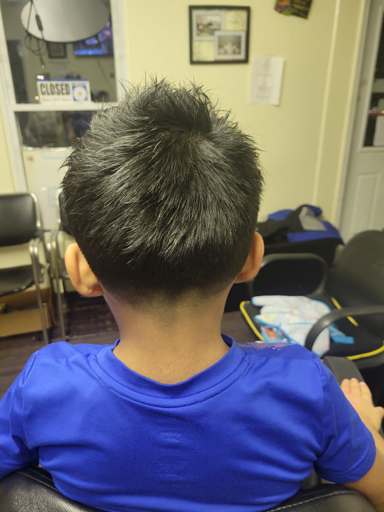 The top hair is left longer and styled in a spiky, tousled fashion for a textured look, while the sides and back feature a smooth, gradual fade that tapers down to the skin near the ears.