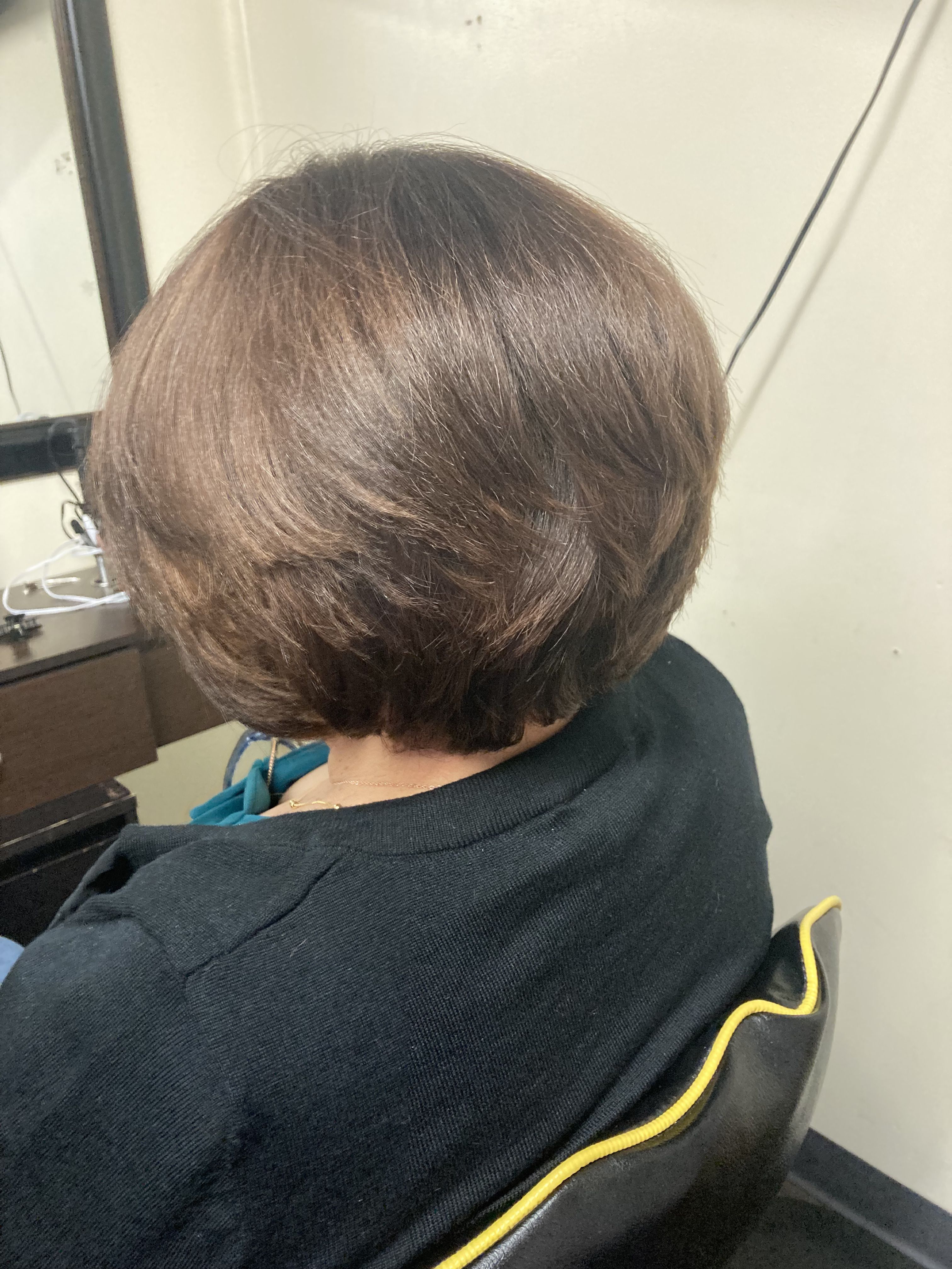 Woman with a short, layered bob haircut. Soft, rounded shape that curves inwards at the ends with a smooth and shiny hair.
