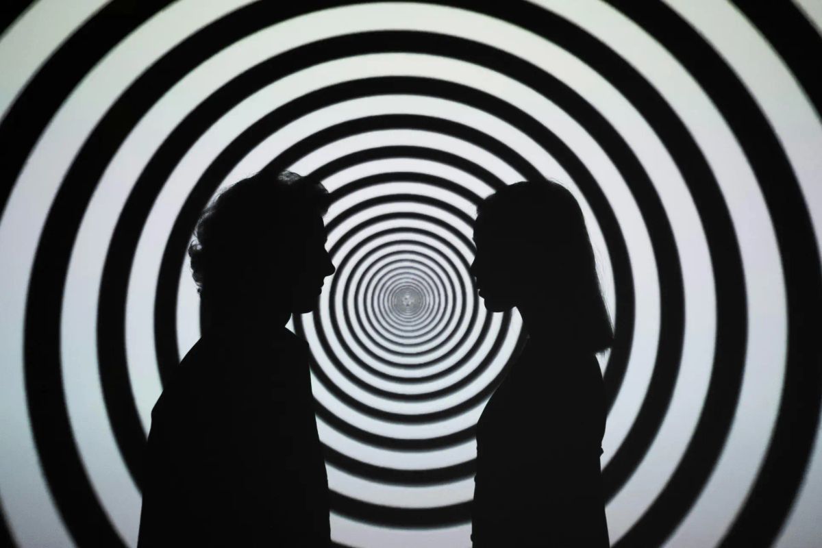 Ein Paar vor einem Hypnose-Symbol, das die mögliche Wirkung von Hypnose bei somatoformen Störungen darstellt.