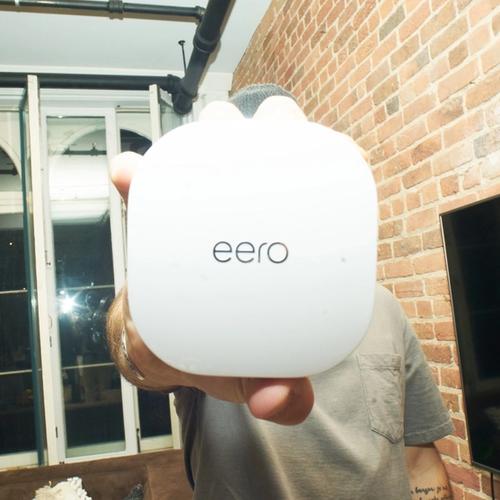 Picture of a trendy guy holding an eero.