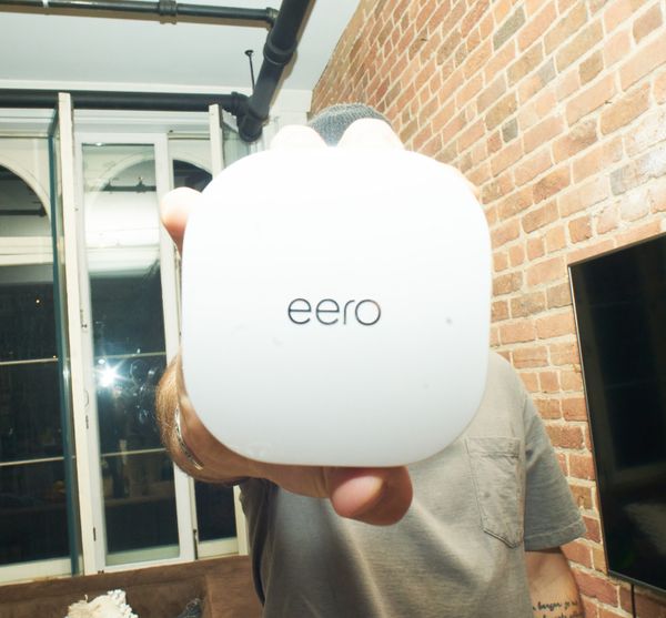 Picture of a trendy guy holding an eero.