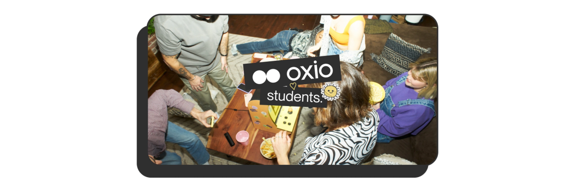 alt="Photo of students hanging out in a dorm playing arcade games around a table with the title oxio heart students."