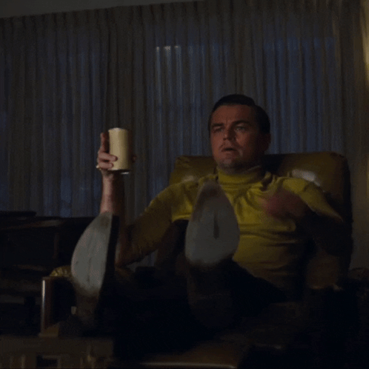 alt="Leonardo Dicaprio holding a can of beer in one hand and jumping up to point at the television with his other hand"