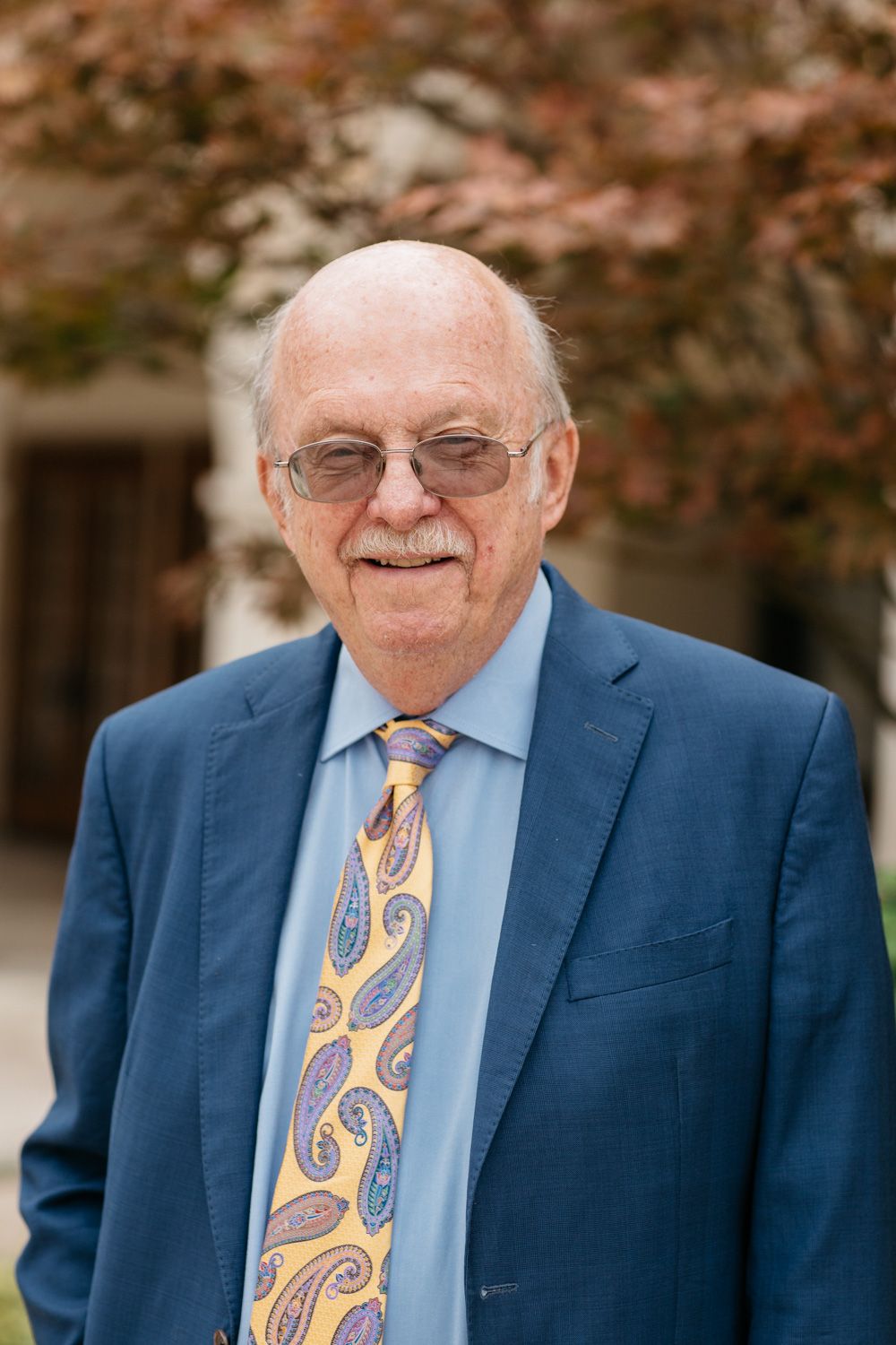 Rev. Dr. Ron C. White, Scholar in Residence. A smiling older gentleman in a blue suit.