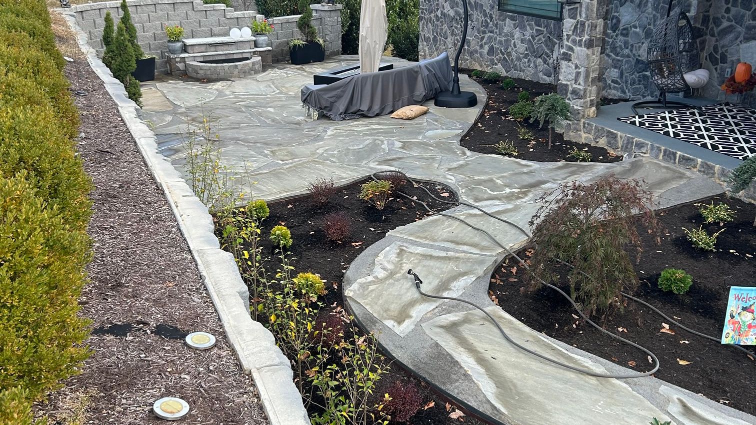 Backyard patio surrounded by tall retaining wall