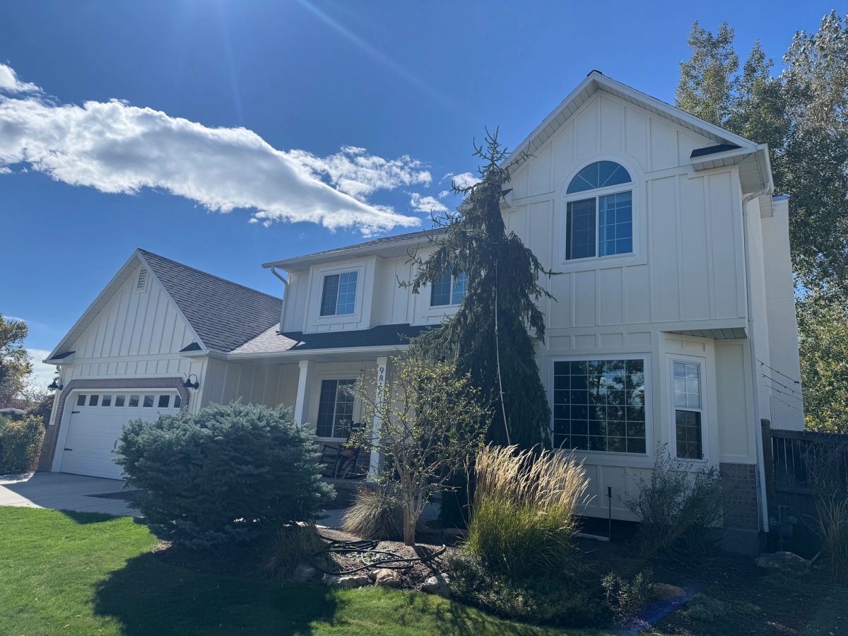 Two-story home with a full set of new white windows, including an arched top window, replaced by Alpine Exteriors.