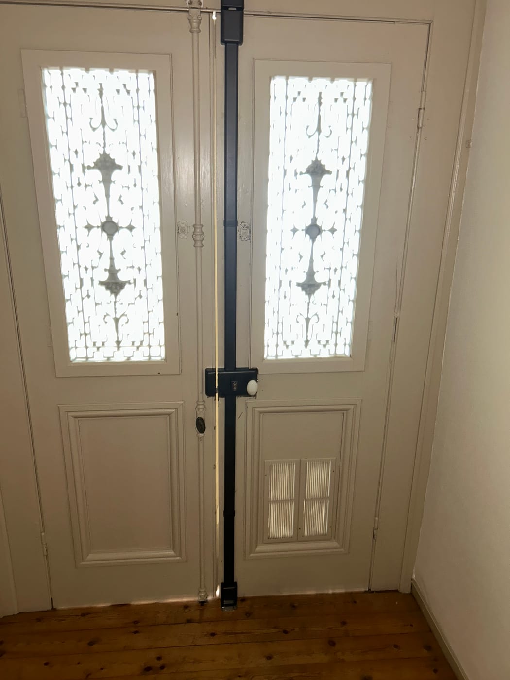 The same double door seen head-on, the black bar running full height between the two leaves