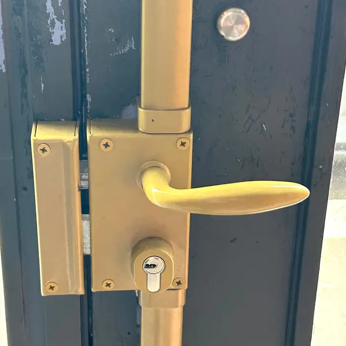 Gold handle set on a dark blue metal door