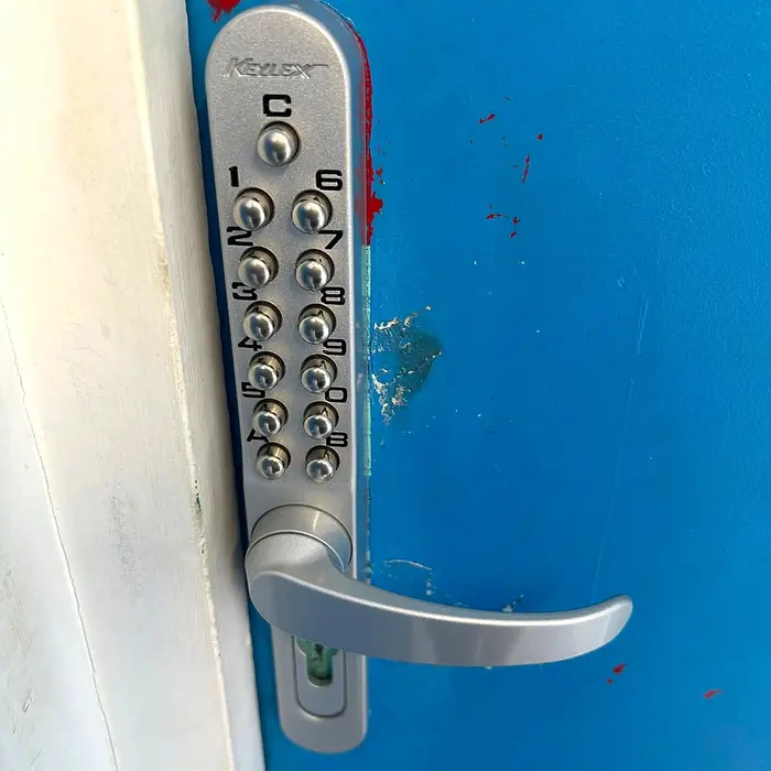 Keypad lock on a blue metal door