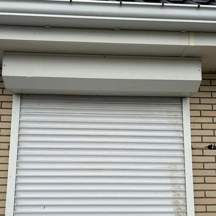 White roller shutter on a brick facade