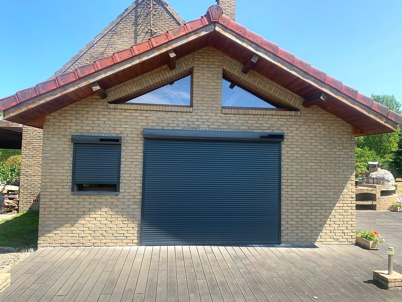 Dark grey roller shutters on a garage and its window
